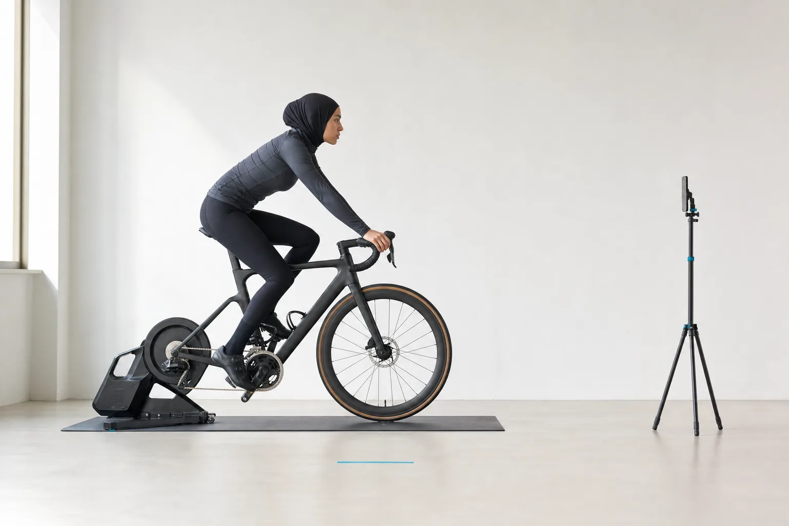 A cyclist pedalling side-on while a stable phone camera records the whole bike and rider