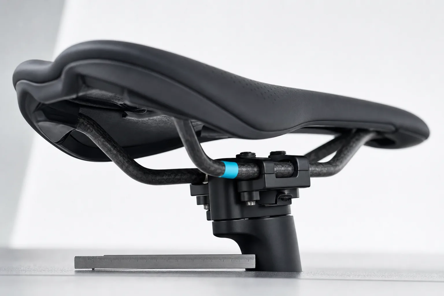 Saddle rails and clamp preserved with a cyan fore-aft reference.